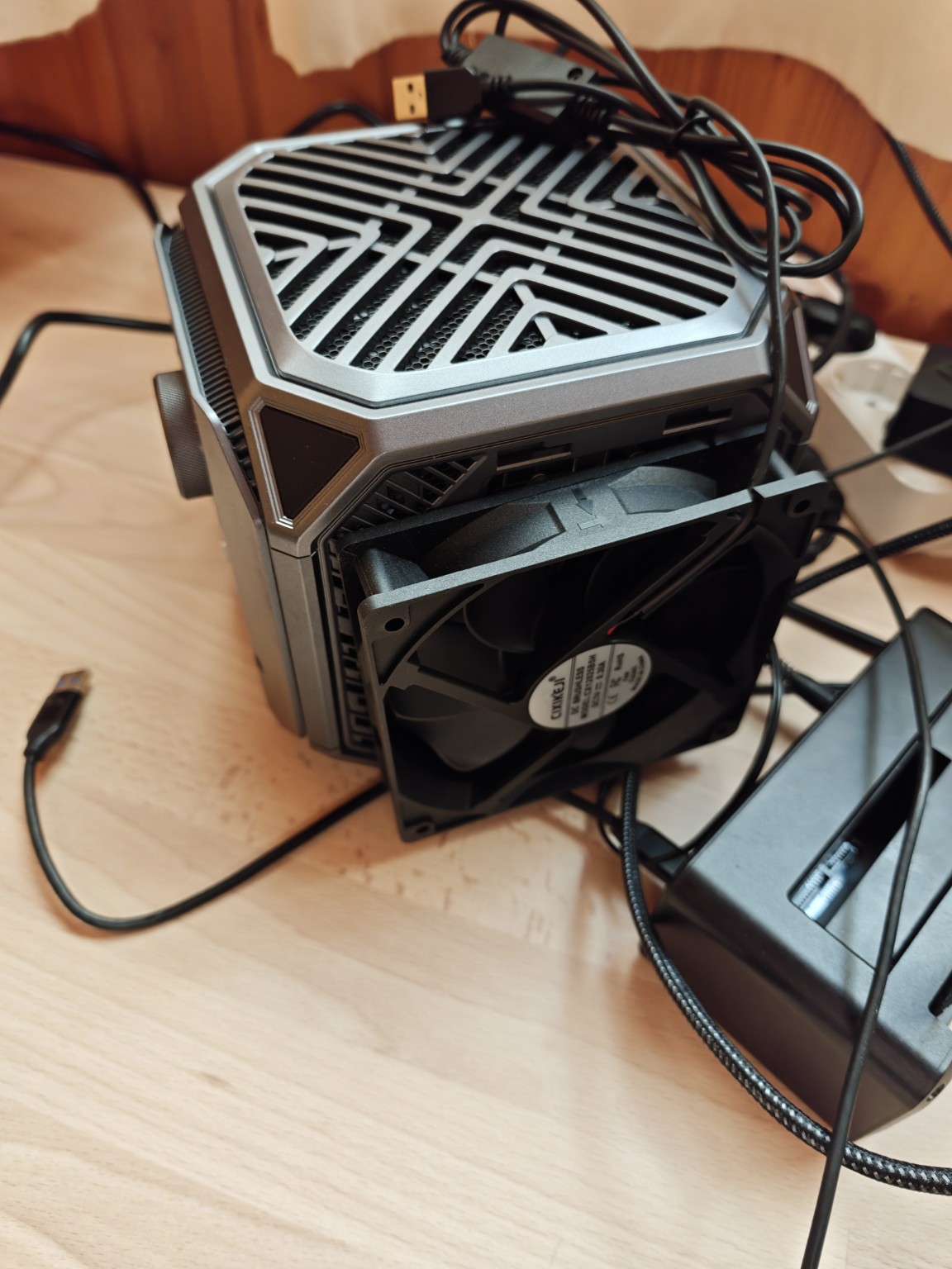Detalle de un ventilador externo colocado junto a la rejilla lateral del mini-PC y su cableado USB.